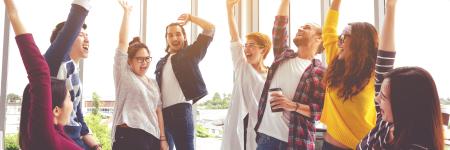group of eight people huddle and high five hands together in office workshop with success or empower expression in teamwork