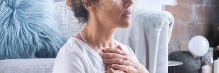 a woman closing her eyes with her hands to her check is meditating