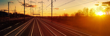 train tracks and the sun setting in the background